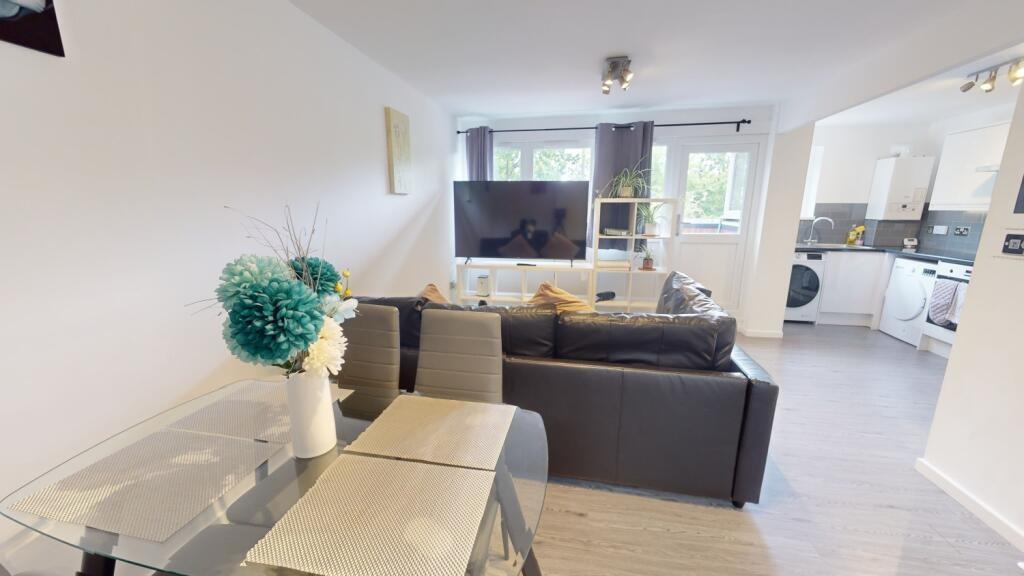 A spacious, modern living room filled with natu...