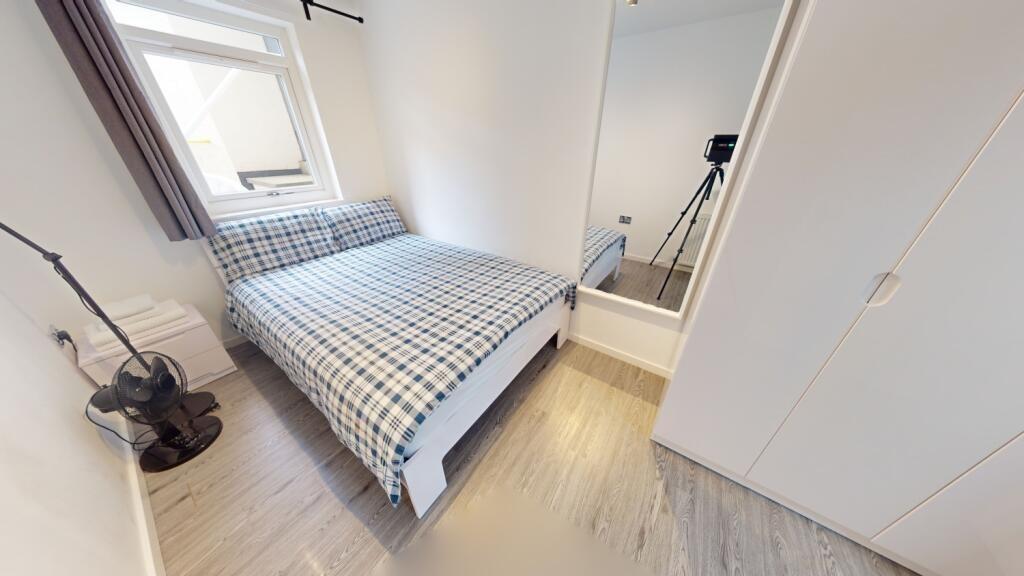 A cozy and well-maintained bedroom featuring a ...