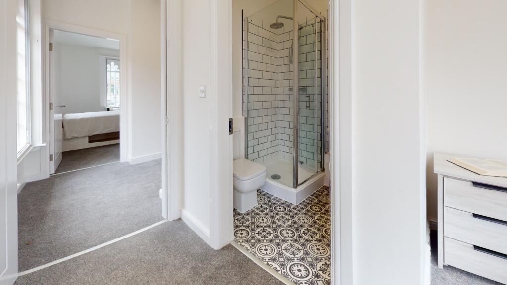 A modern bathroom featuring a spacious shower c...