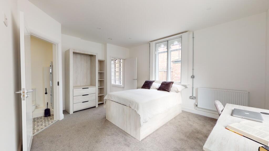 A spacious and well-lit master bedroom featurin...