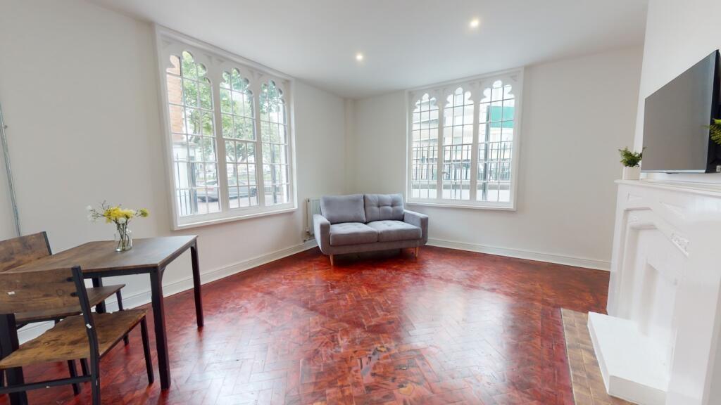 Bright and spacious living room with large wind...