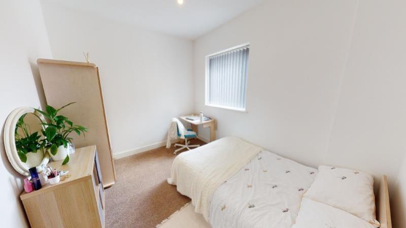 A bright and tidy single bedroom featuring a co...