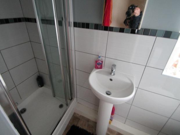 A clean, functional bathroom with a shower and ...