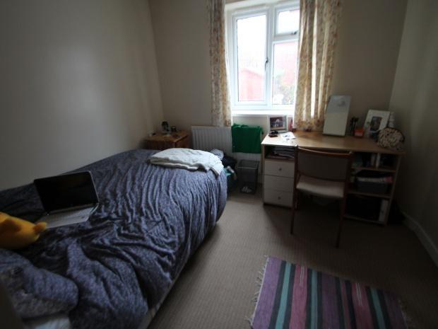 A cozy single bedroom featuring a neatly made b...