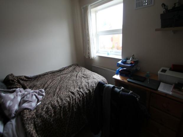 A cozy bedroom with a bed placed against the wa...