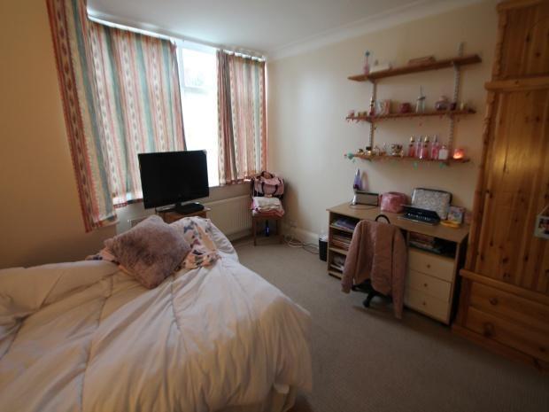 A cozy bedroom featuring a neatly made bed, a s...