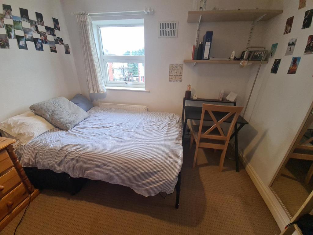 A cozy bedroom featuring a neatly made bed with...