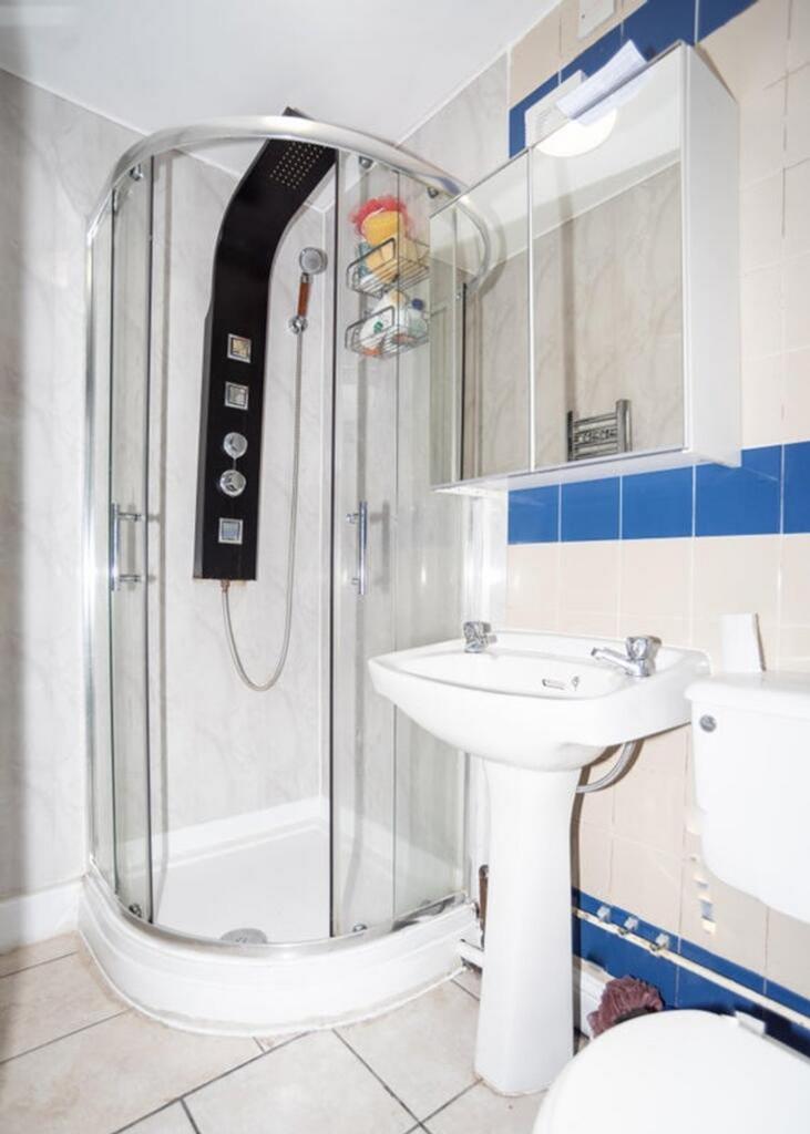 A modern bathroom featuring a sleek glass showe...