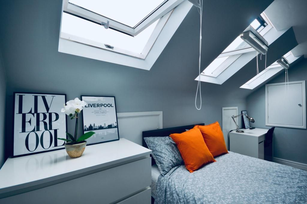 A spacious and well-lit master bedroom featurin...