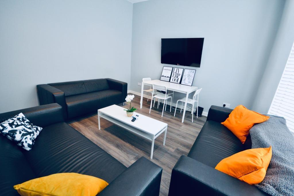 A spacious and well-lit living room featuring m...