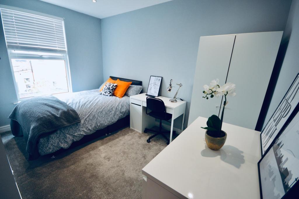 A bright and tidy double bedroom featuring a co...