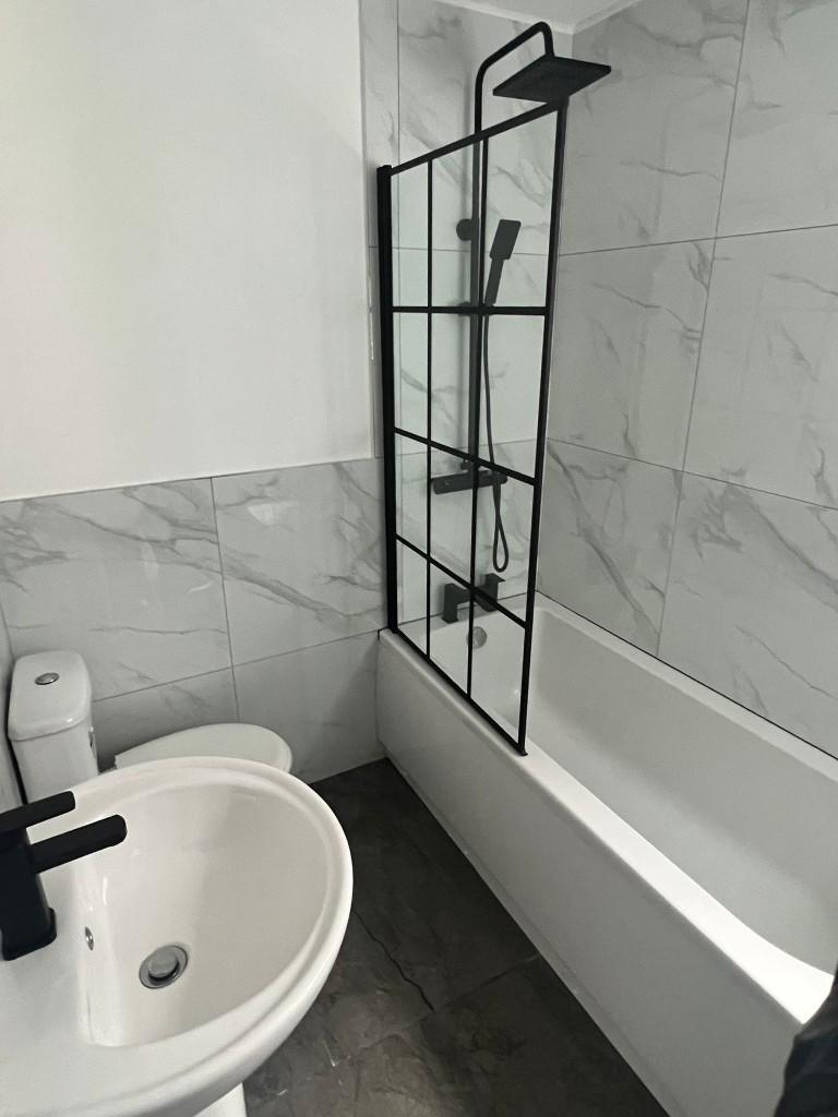 A modern bathroom featuring a bathtub with a bl...