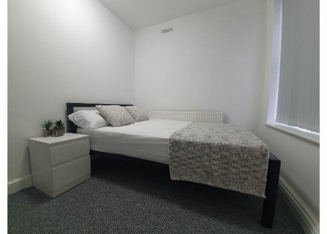 A spacious and well-lit double bedroom featurin...