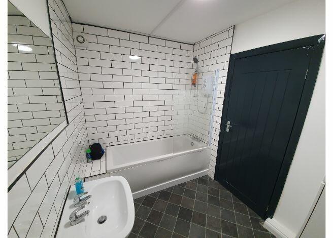 A spacious bathroom with a bathtub and a washba...