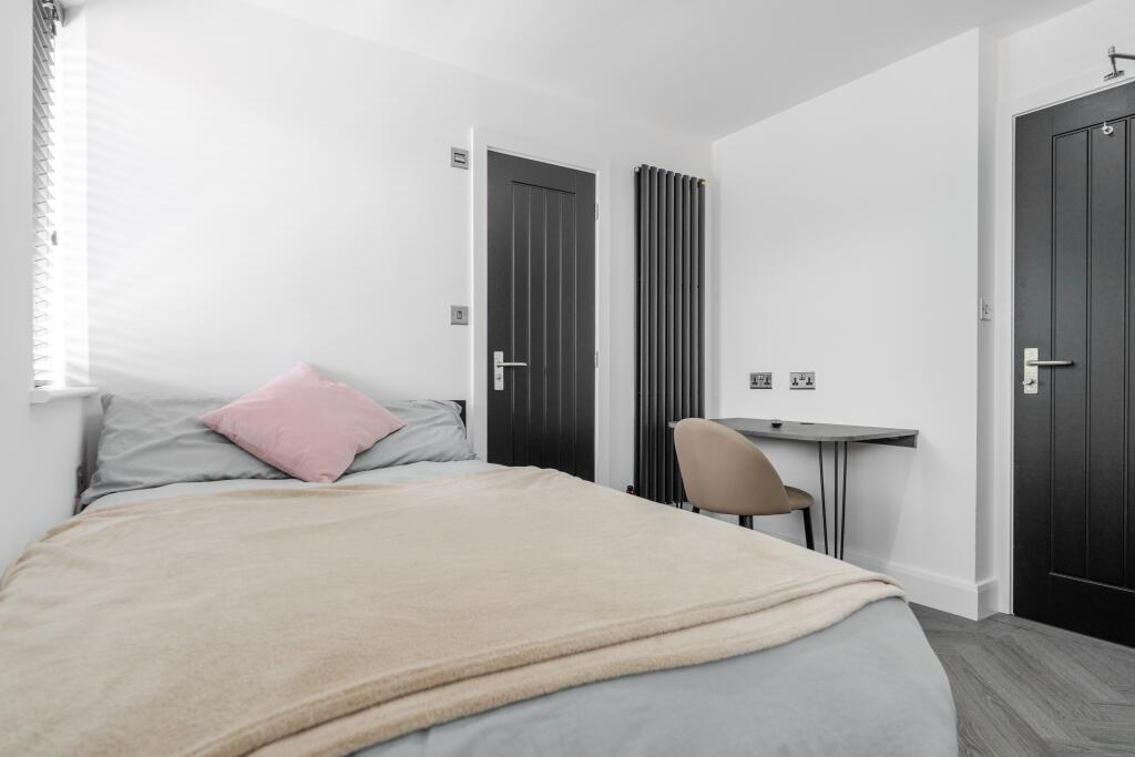 A bright and welcoming double bedroom featuring...