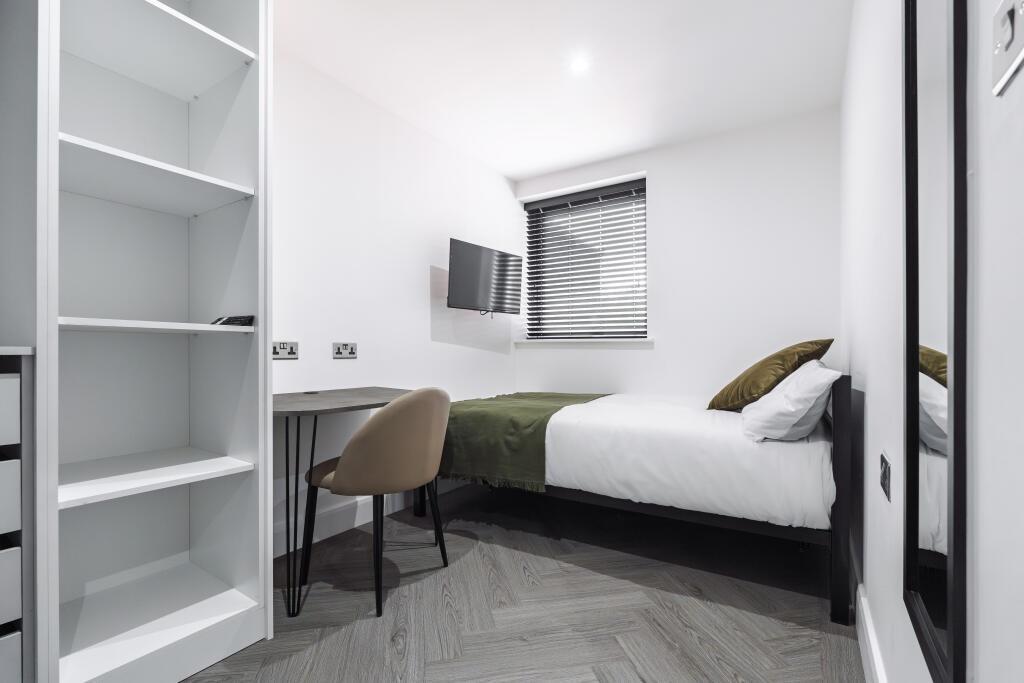 A bright and tidy single bedroom featuring a co...