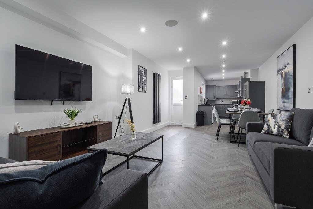 A spacious, modern living room featuring contem...