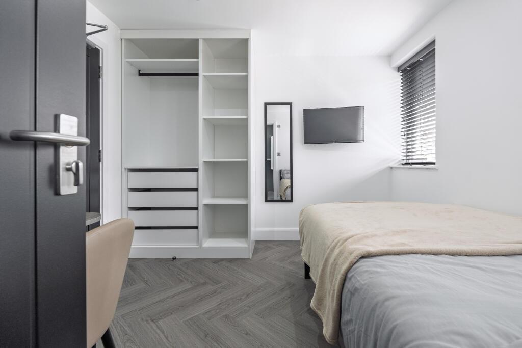 A modern, neatly maintained bedroom with ample ...