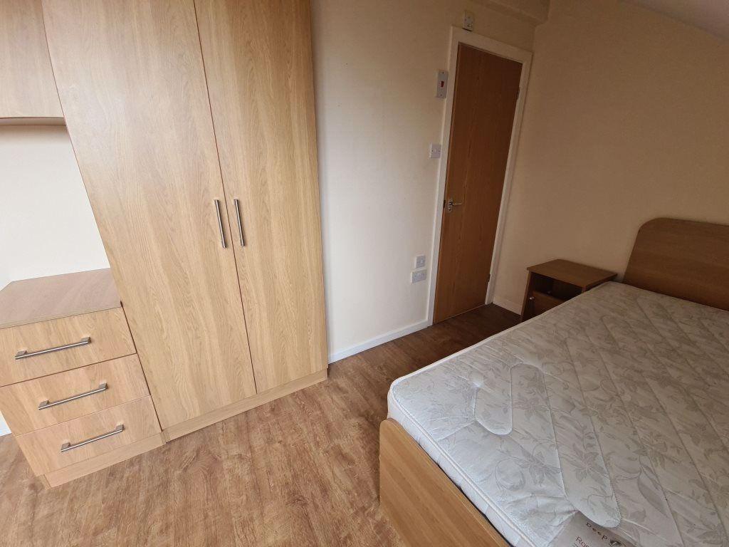 A cozy bedroom featuring a double bed, a fitted...