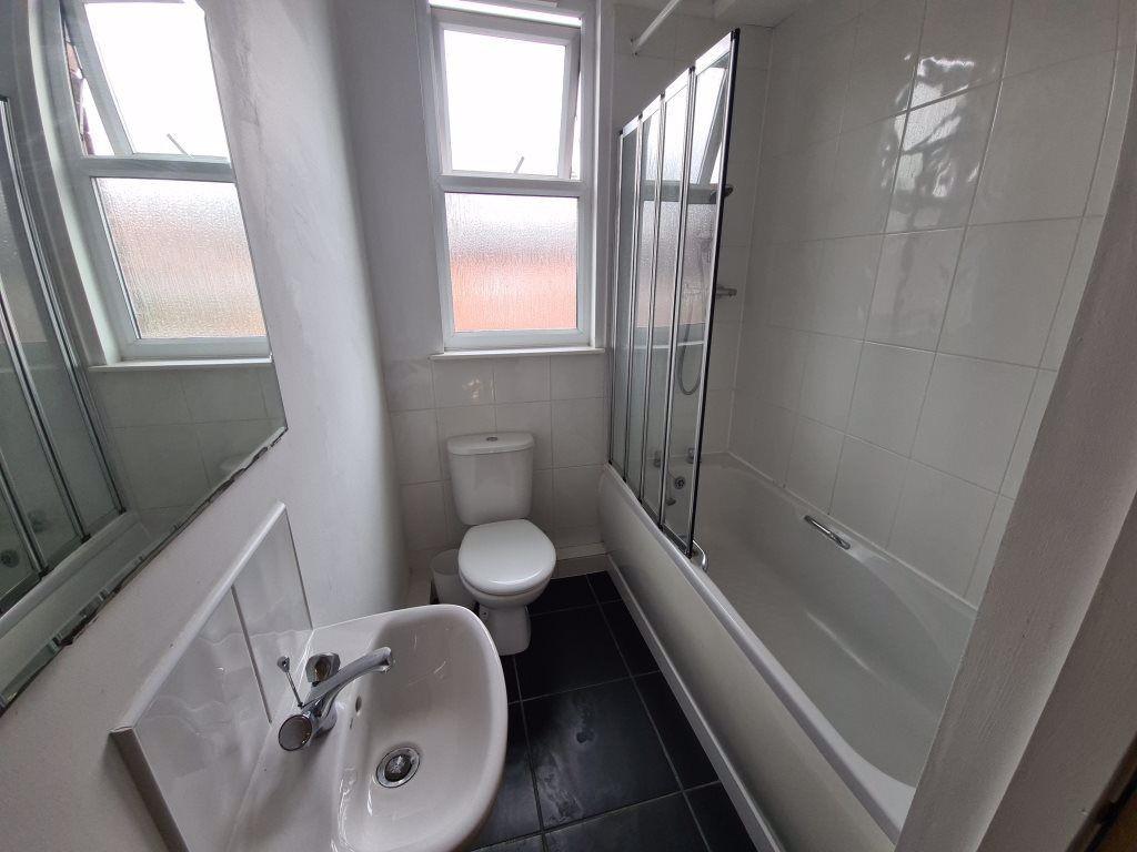 A bright and clean bathroom featuring a bathtub...