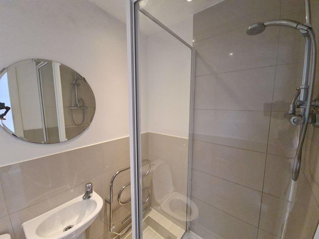 A modern bathroom featuring a shower with glass...