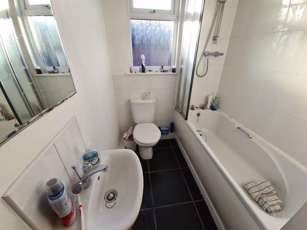 A clean and bright bathroom featuring a bathtub...