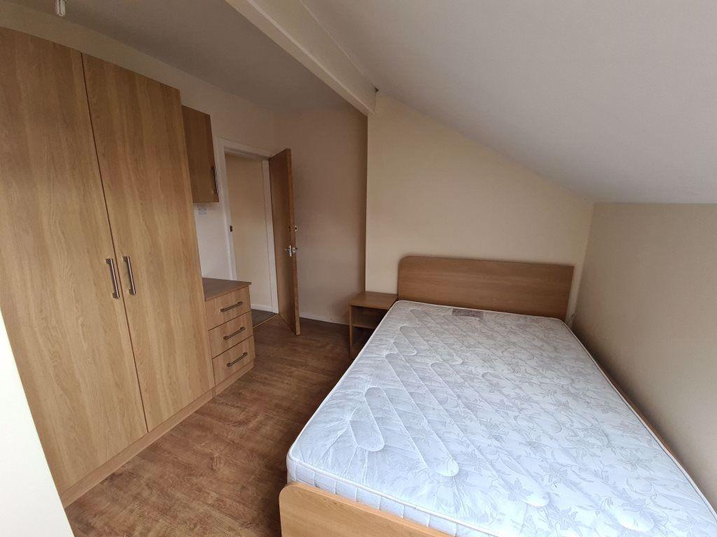A bright and tidy bedroom featuring a double be...
