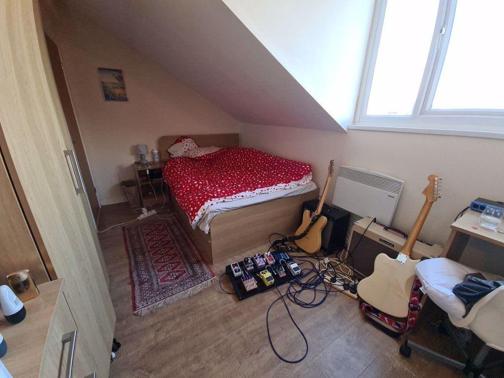 A cozy single bedroom featuring a bed with a re...