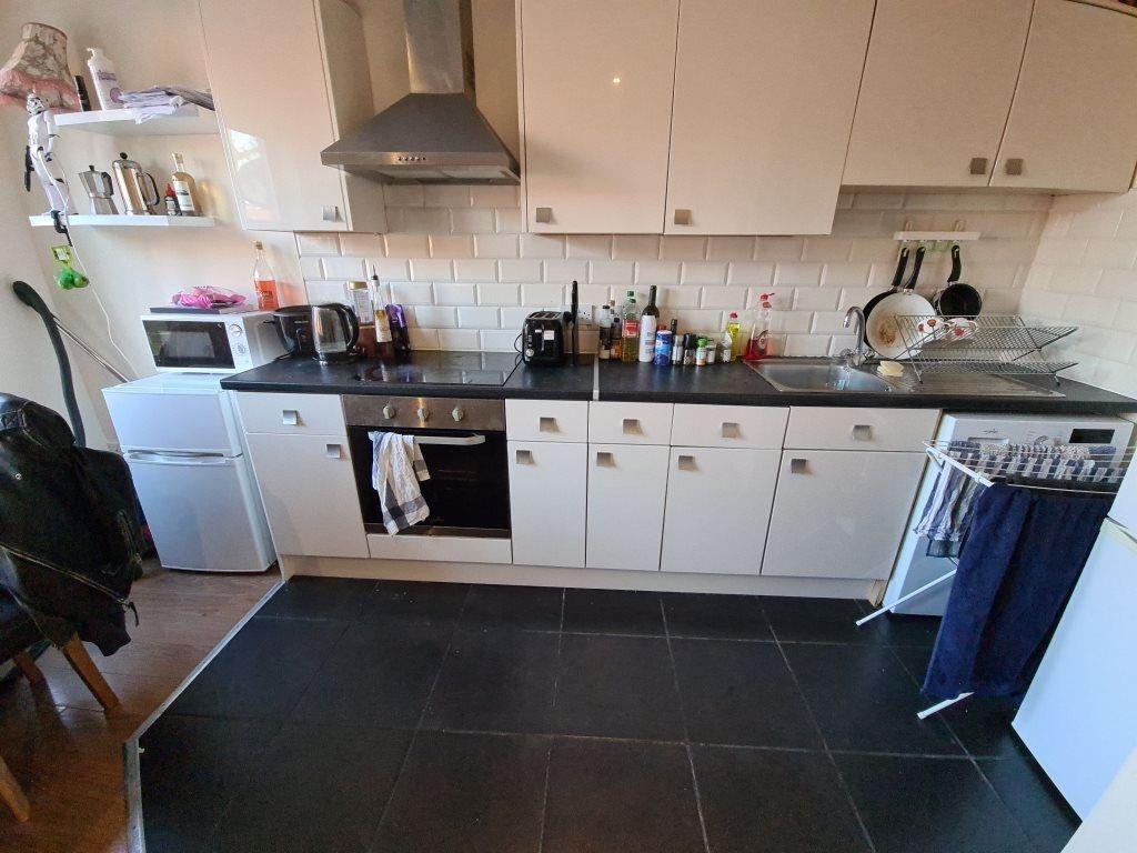 A modern kitchen featuring white cabinets, a bu...