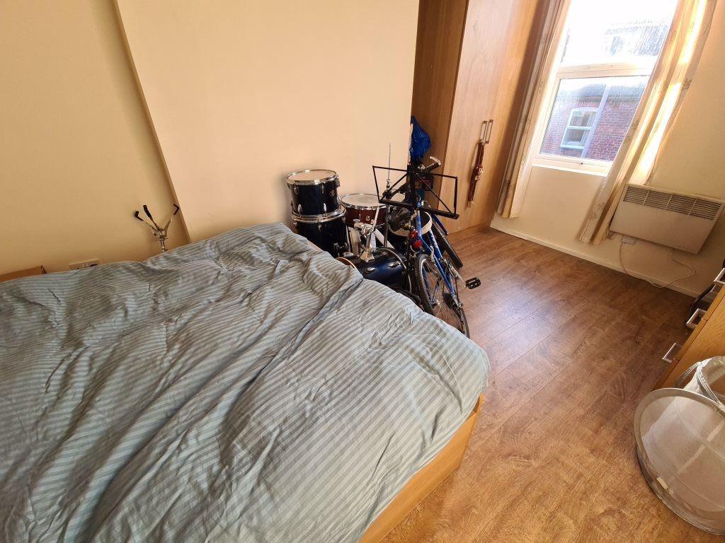 A cozy bedroom with a bed, some personal items,...