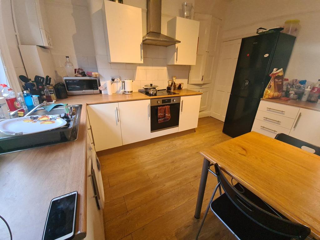 A well-maintained kitchen with ample lighting, ...