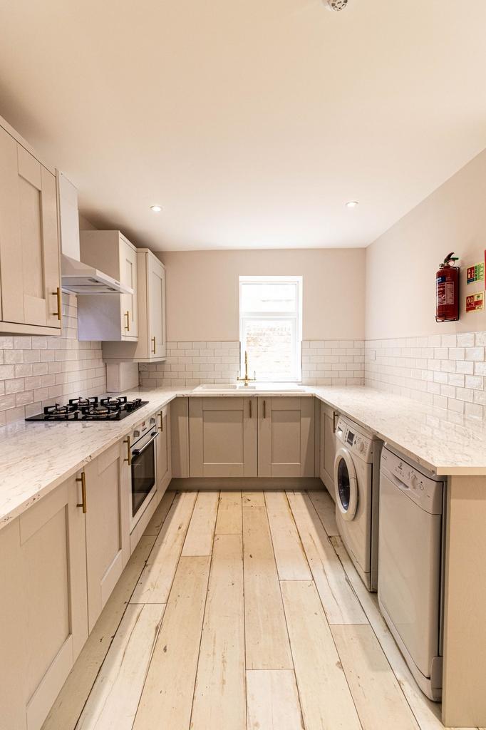 Bright and clean kitchen with modern cabinetry,...