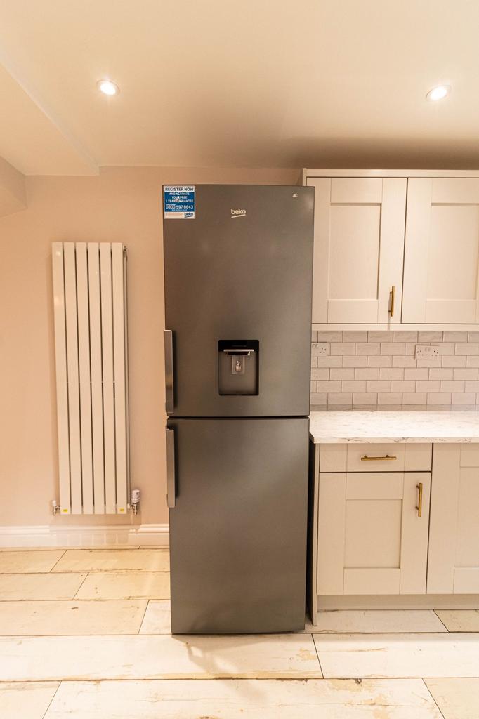Modern kitchen with a sleek grey refrigerator a...