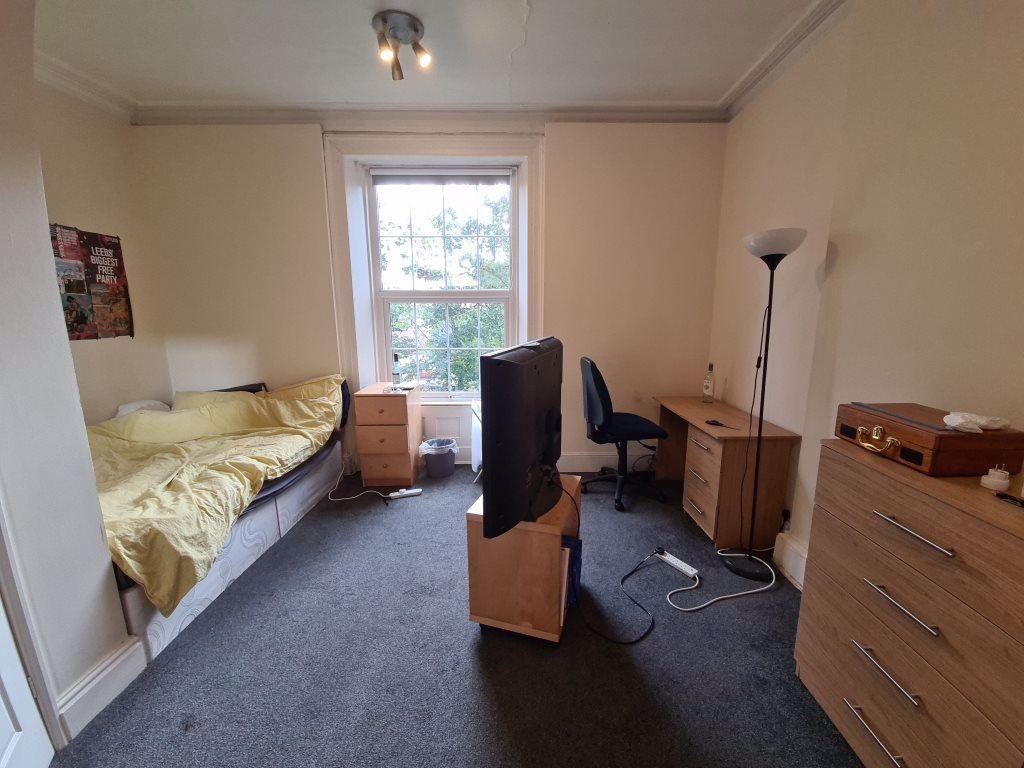 Bright and neatly arranged single bedroom featu...