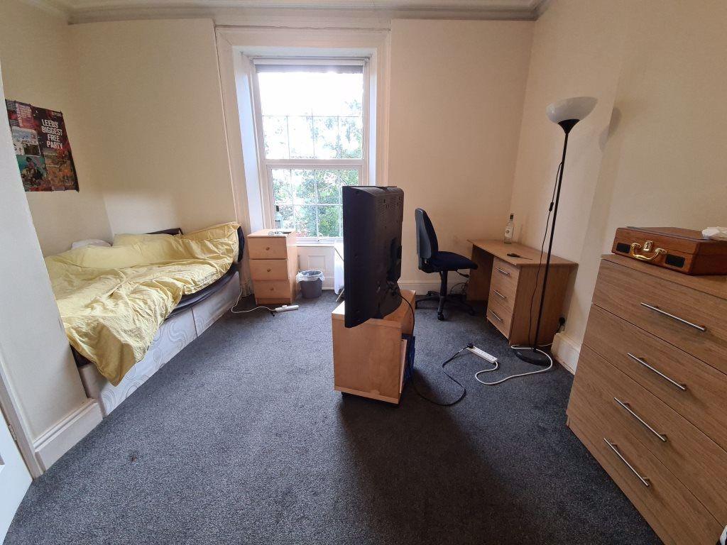 Cozy single bedroom featuring a comfortable bed...