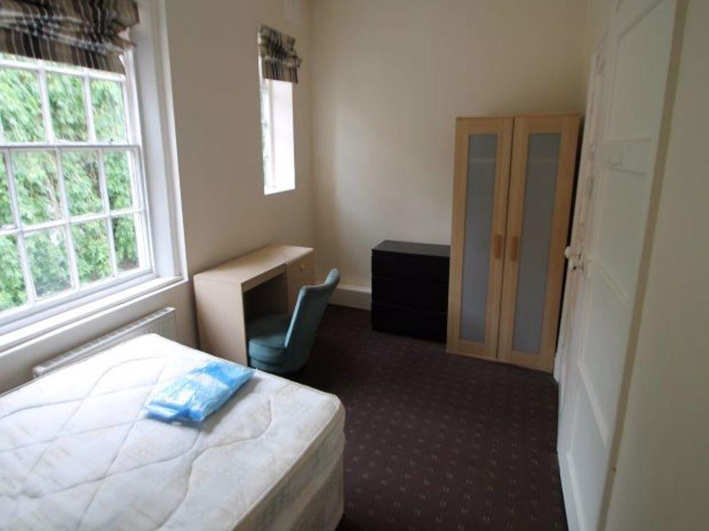 A cozy single bedroom featuring a comfortable b...
