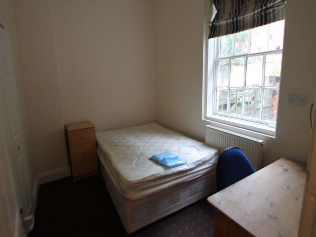 A cozy single bedroom featuring a neatly made b...
