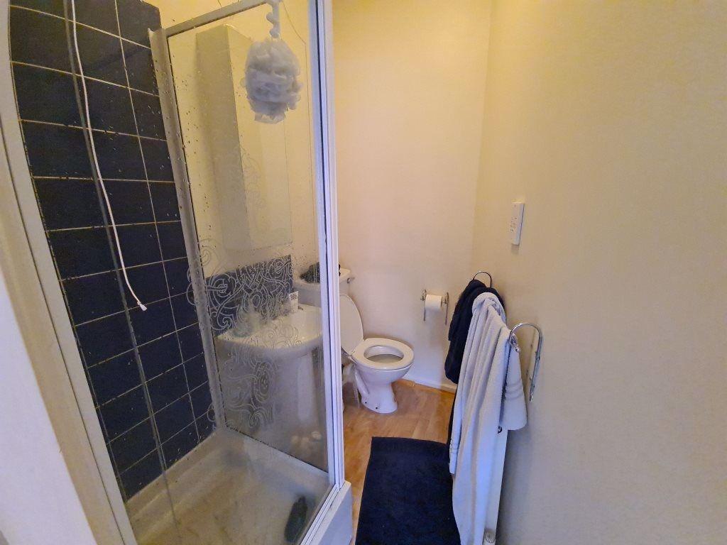 A compact bathroom featuring a modern shower cu...