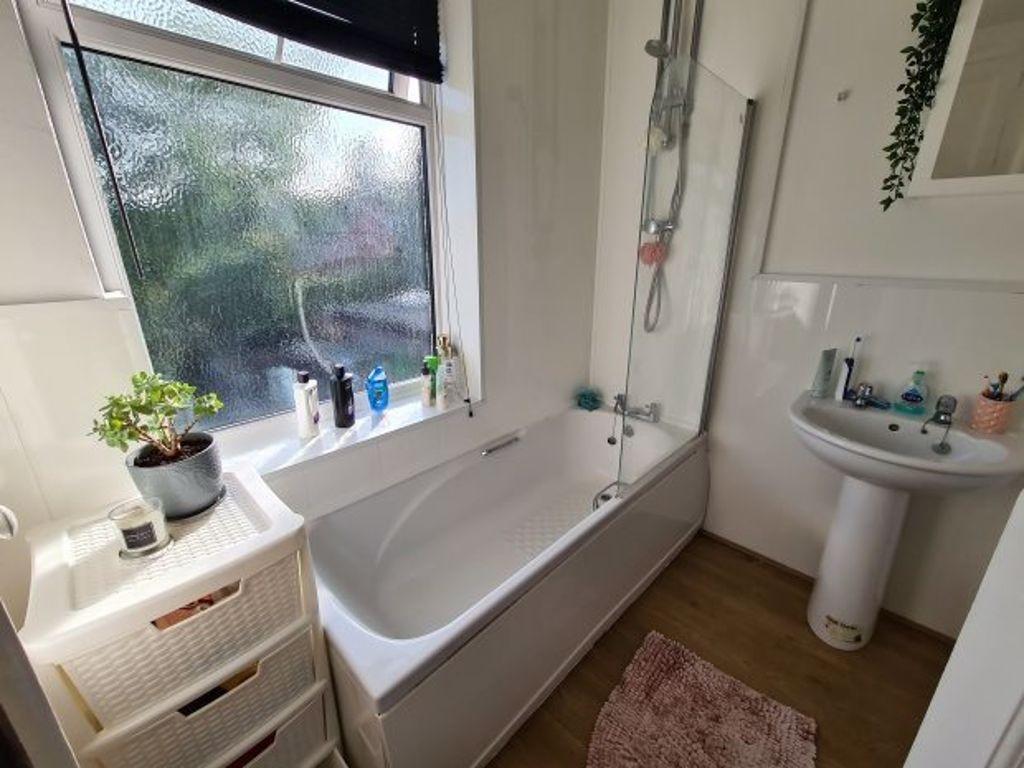 A spacious, clean bathroom featuring a large ba...