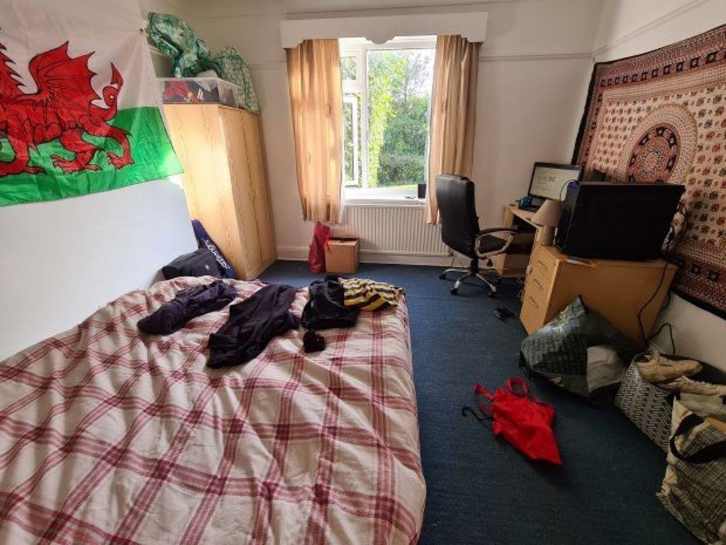 A cozy bedroom featuring a double bed with a ch...