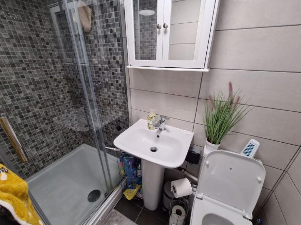 A tidy bathroom featuring a white sink, toilet,...