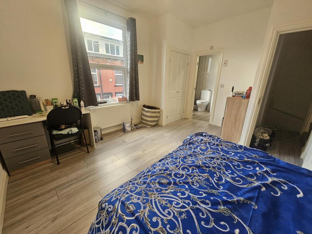 A bright double bedroom featuring a large windo...