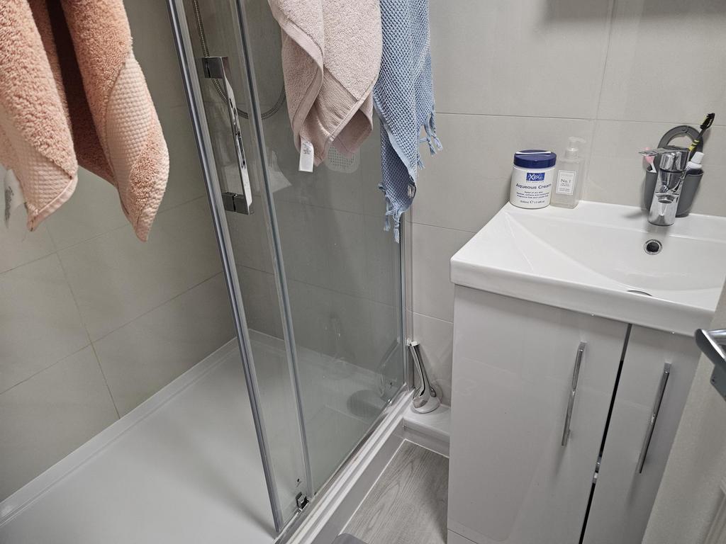 A modern bathroom featuring a glass-enclosed sh...