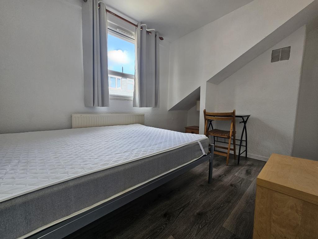 A bright and inviting bedroom featuring a comfo...