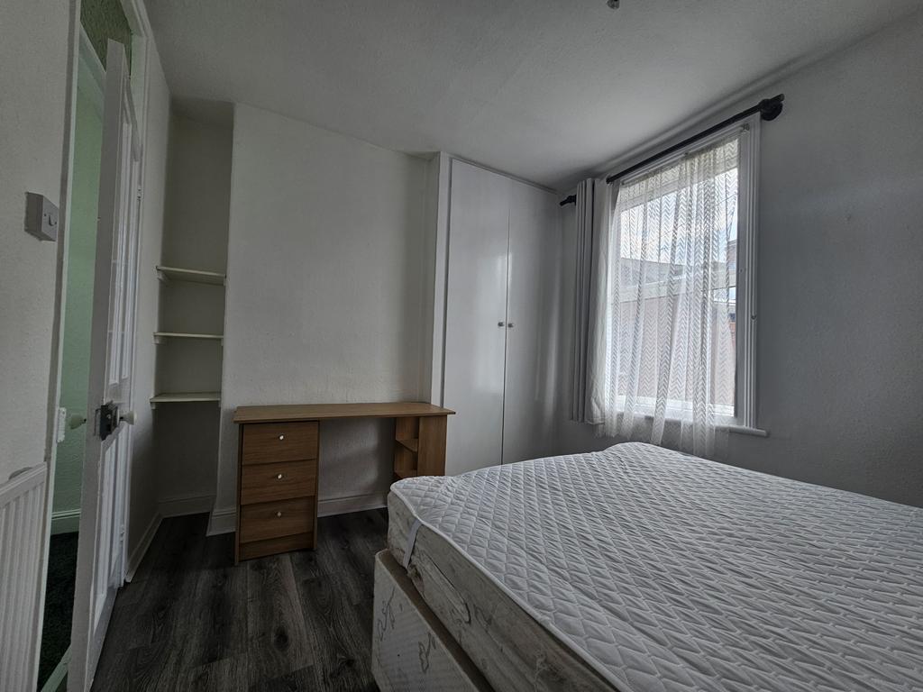A bright and tidy bedroom featuring a comfortab...