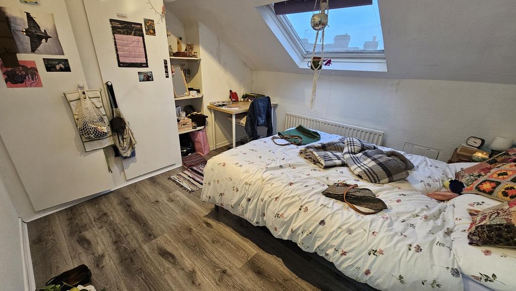 A cozy bedroom featuring a double bed with neat...