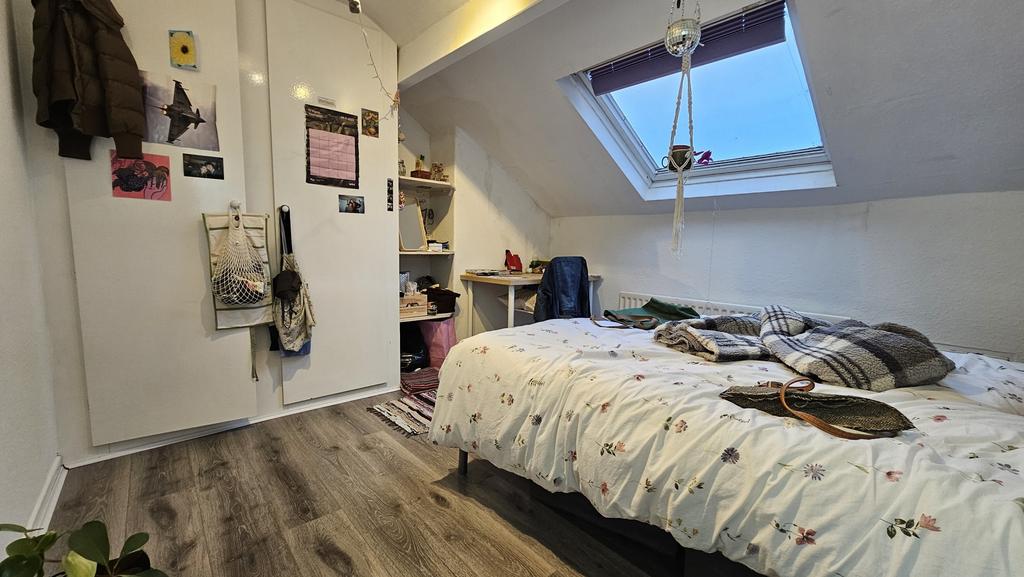 A cozy bedroom with a large bed, well-lit by a ...