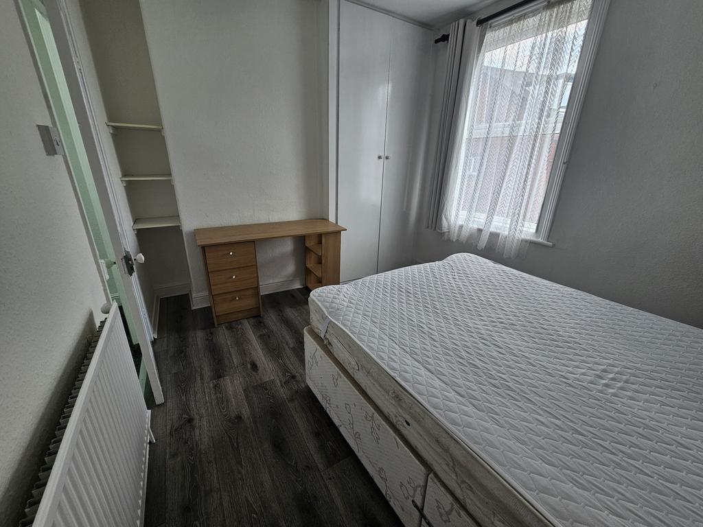 A well-lit, neatly maintained bedroom with a co...