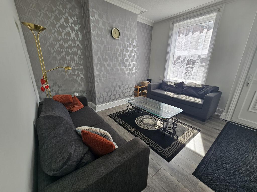 A spacious and well-lit living room featuring c...