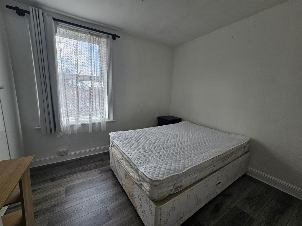 A modestly sized bedroom with a large window th...